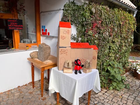 Der Granit-Wettkampfstein auf seinem Holzbock, daneben der Tisch mit den Preisen